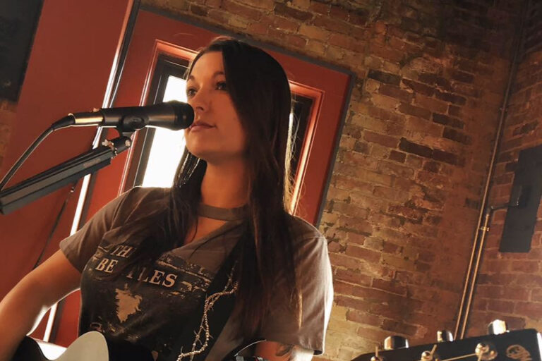 woman singing and playing the guitar